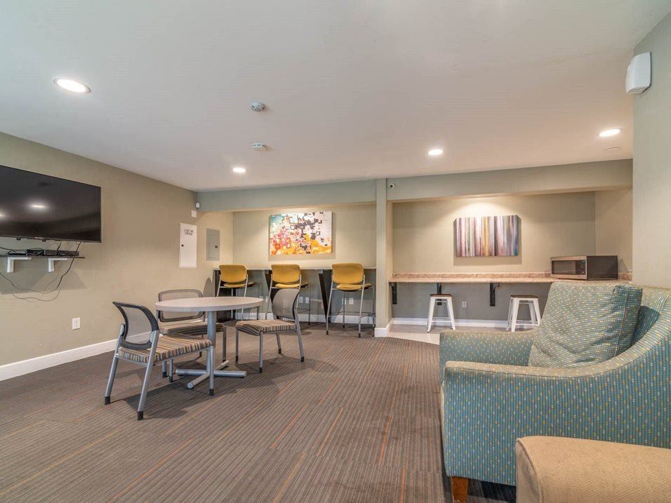 a lobby with tables and chairs and a television