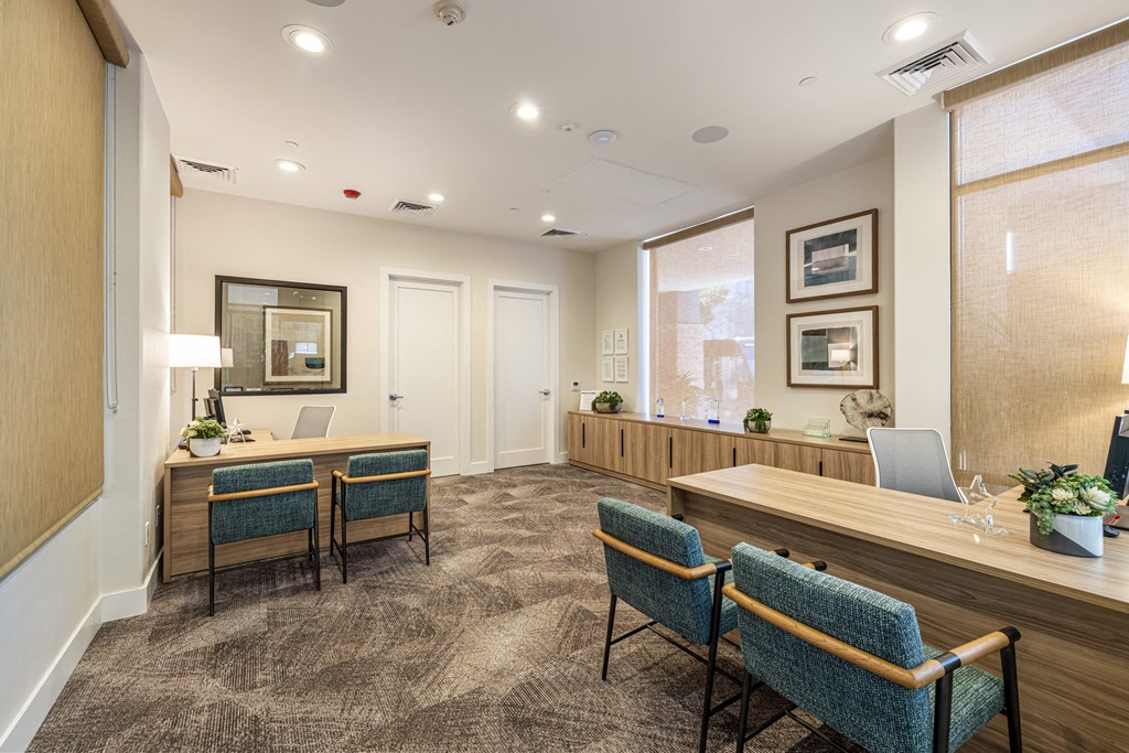 a conference room with chairs and a desk and a window