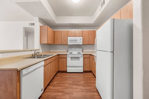 A kitchen with wooden cabinets and white appliances.