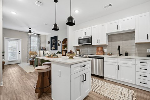 A modern kitchen with white cabinets and a central island.