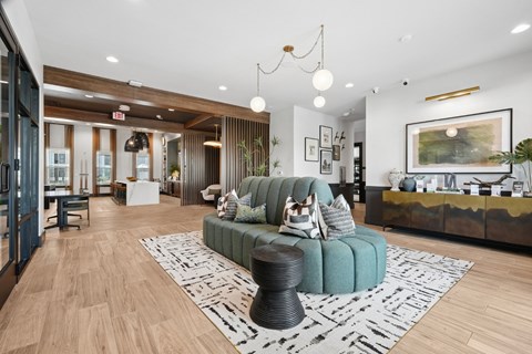 A living room with a green couch and a wooden floor.