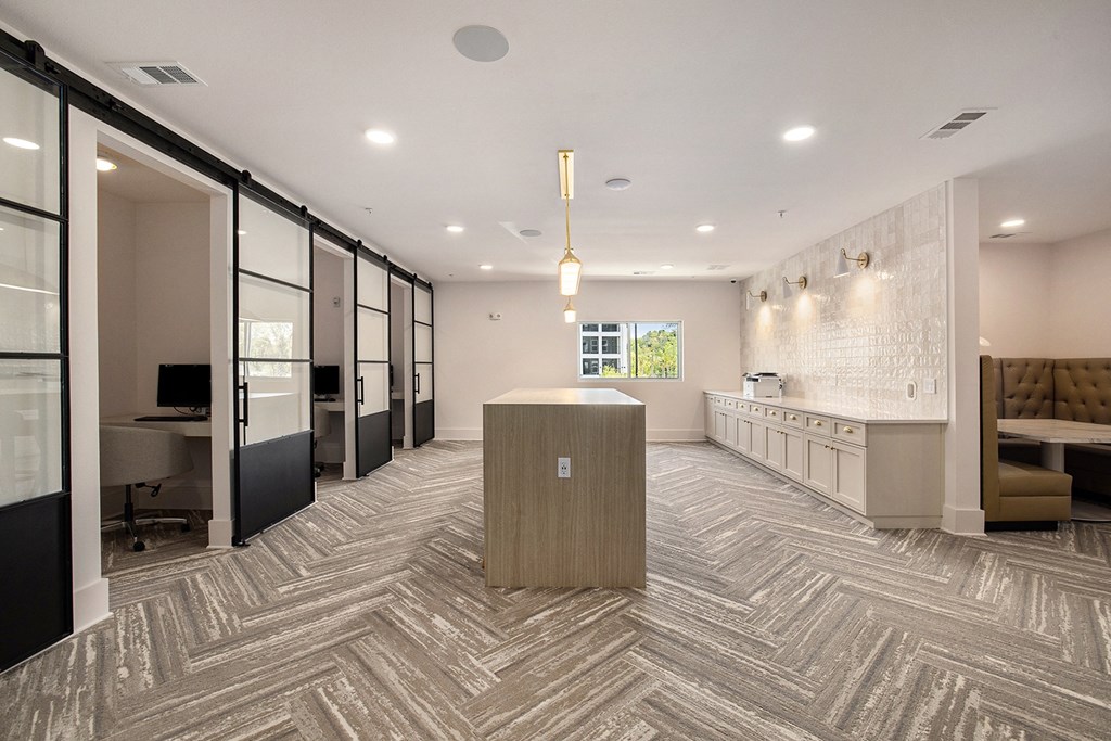 A modern office space with a reception desk and a view of the outdoors.
