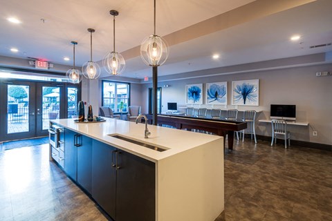 A kitchen with a counter and chairs.