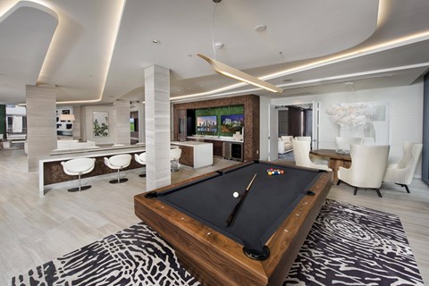 A pool table is in the middle of a room with a zebra print rug.