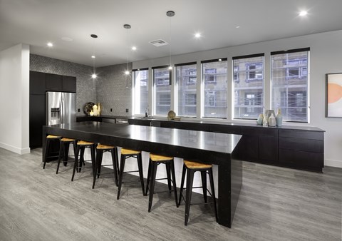 a large kitchen with a long island with yellow chairs
