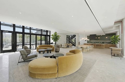 A modern living room with a large yellow circular sofa and a dining area in the background.