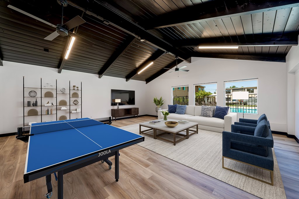 A blue ping pong table is in the middle of a living room.