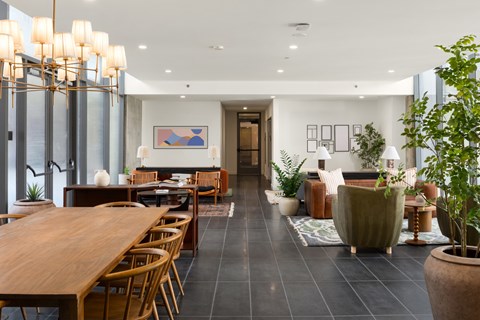 A modern dining room with a long wooden table and chairs.