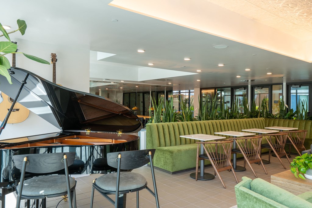 a piano sits in the middle of a room with tables and chairs