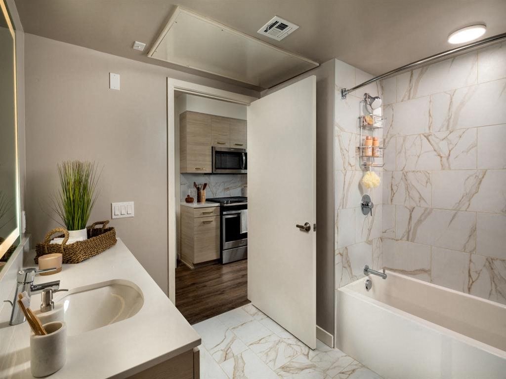 a bathroom with a tub and a sink and a shower