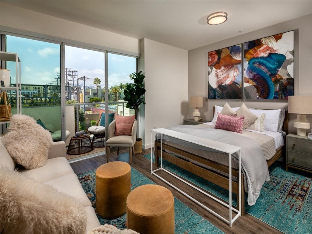 a bedroom with a bed and a living room with a window