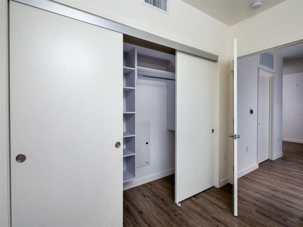 a bedroom with a closet and a door open
