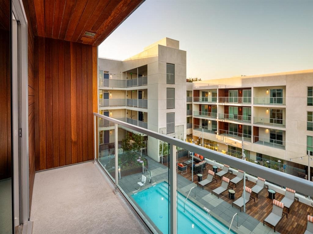 a balcony with a pool and a building in the background