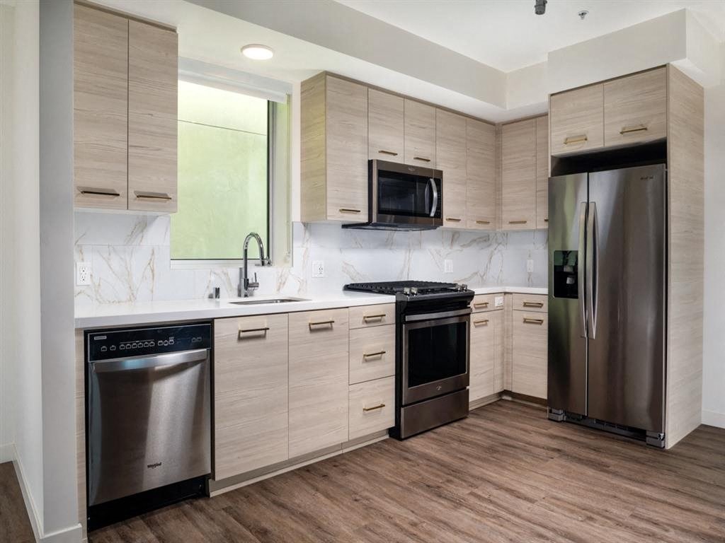 a kitchen with wooden cabinets and stainless steel appliances
