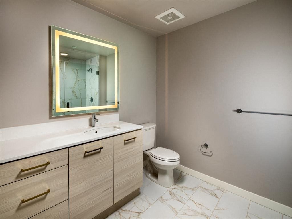 a bathroom with a toilet and a sink and a mirror