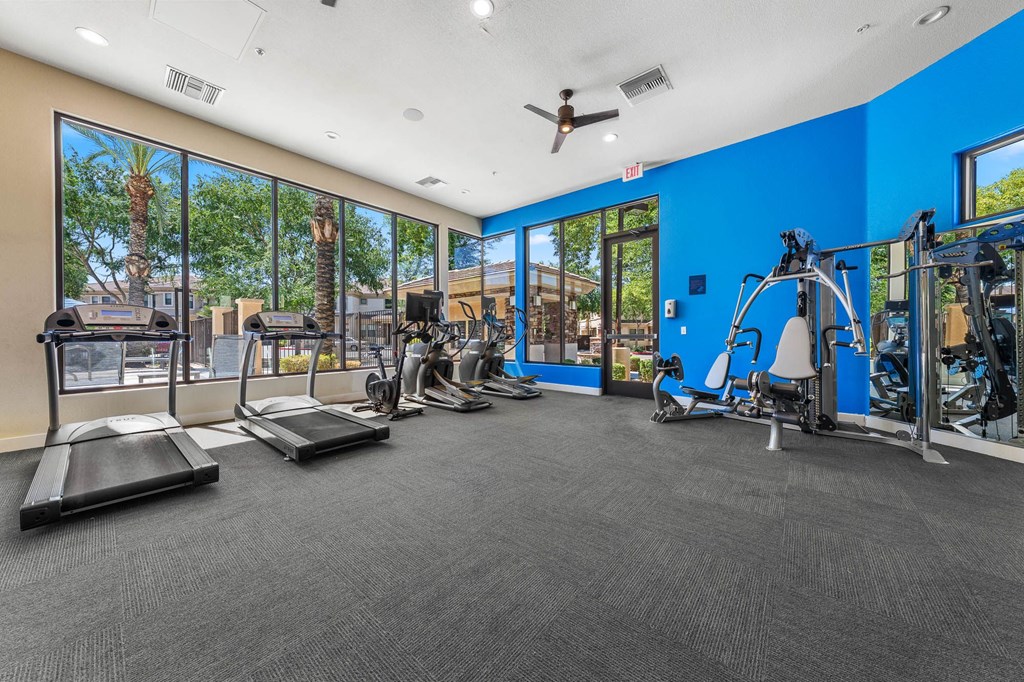 A gym with treadmills, weights, and exercise equipment.