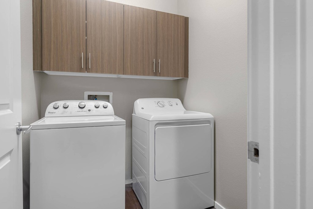 Two white front loading washing machines in a laundry room.