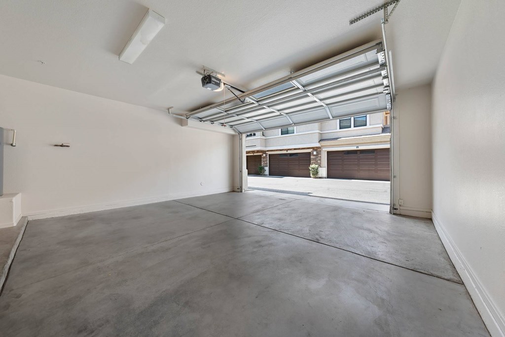A large empty room with a concrete floor and white walls.