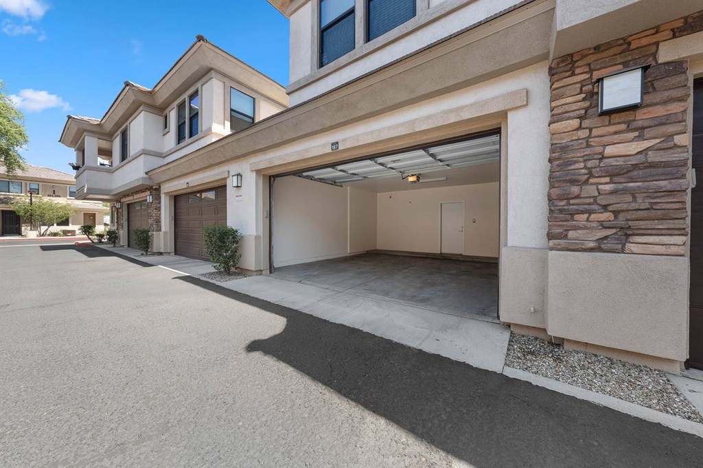 A modern house with a stone wall and a garage.