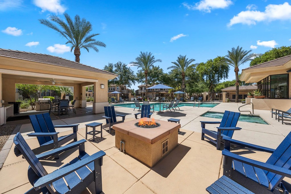 A poolside area with blue lounge chairs and a hot tub.