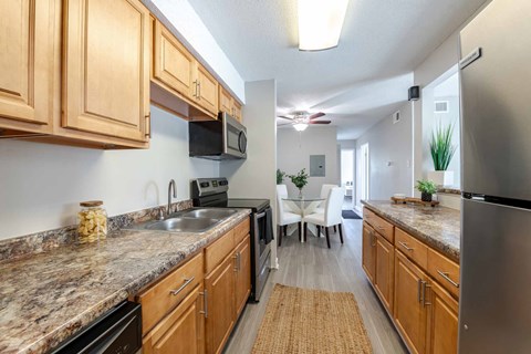 A kitchen with wooden cabinets and granite countertops.