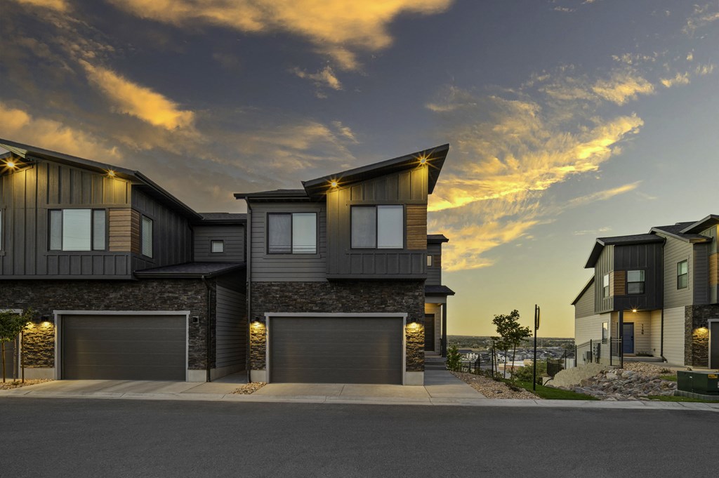 an image of a house with garage doors at dusk