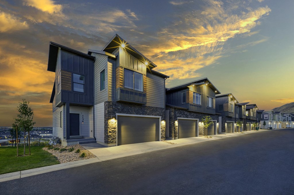 a row of houses with garage doors at sunset