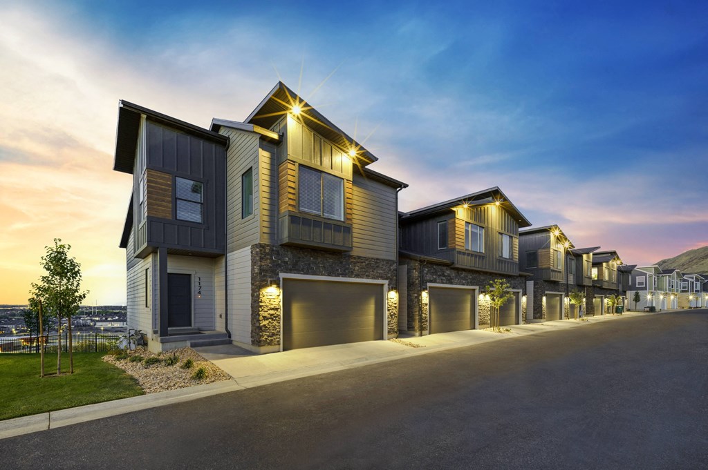 a row of houses with lights on at dusk