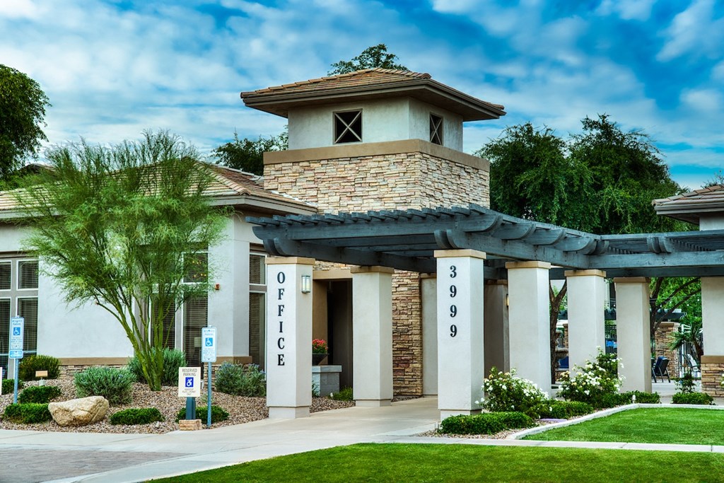 A building with the word "OFFICE" on it is surrounded by greenery.