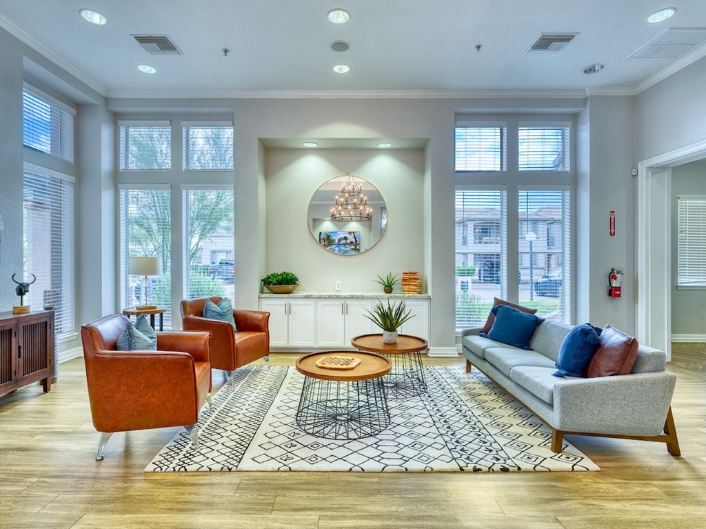 A living room with a grey sofa, a coffee table, and a chandelier.
