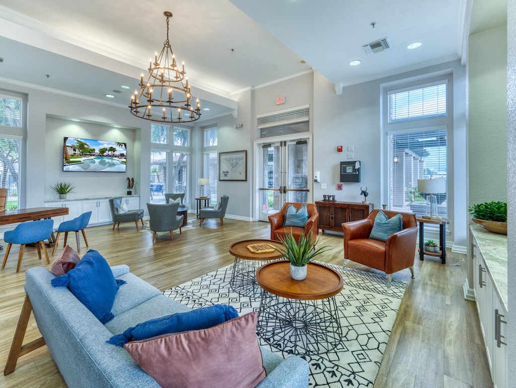 A living room with a grey couch and a chandelier.