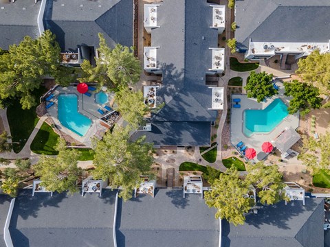 a birds eye view of the resort with pools and trees