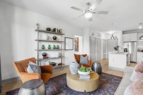 A living room with a white ceiling fan and a rug on the floor.