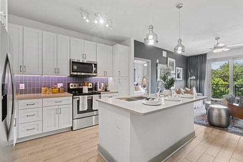 A modern kitchen with a large island and stainless steel appliances.