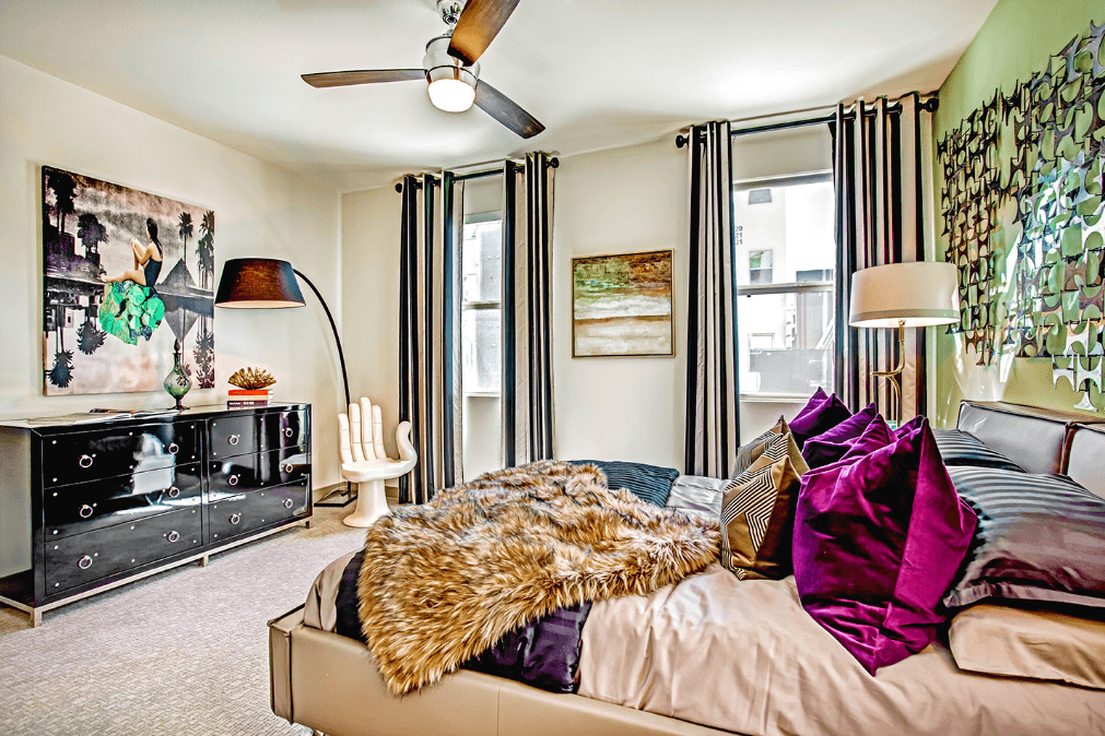 a bedroom with a large bed and a dresser with a tv on top of it