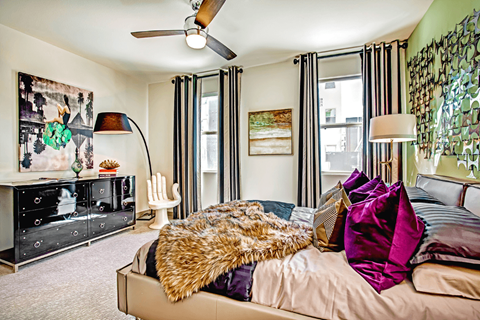 a bedroom with a large bed and a dresser with a tv on top of it