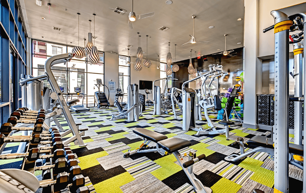 a spacious fitness center with cardio machines and other exercise equipment