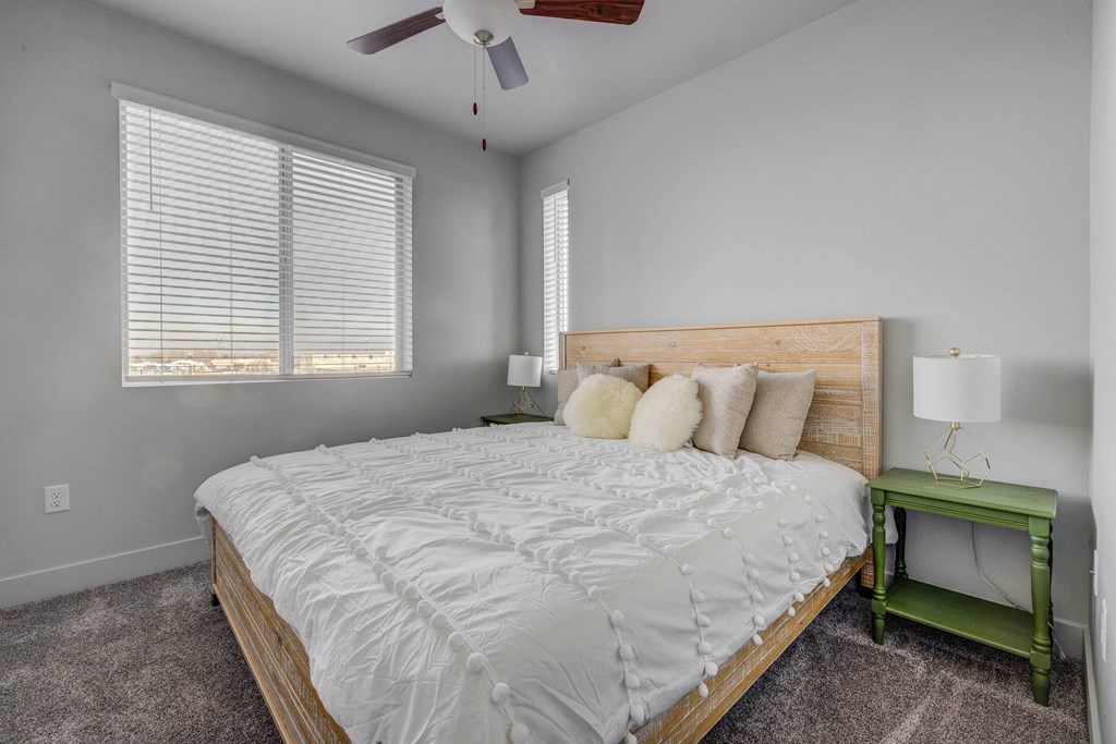 a bedroom with a large bed and a ceiling fan
