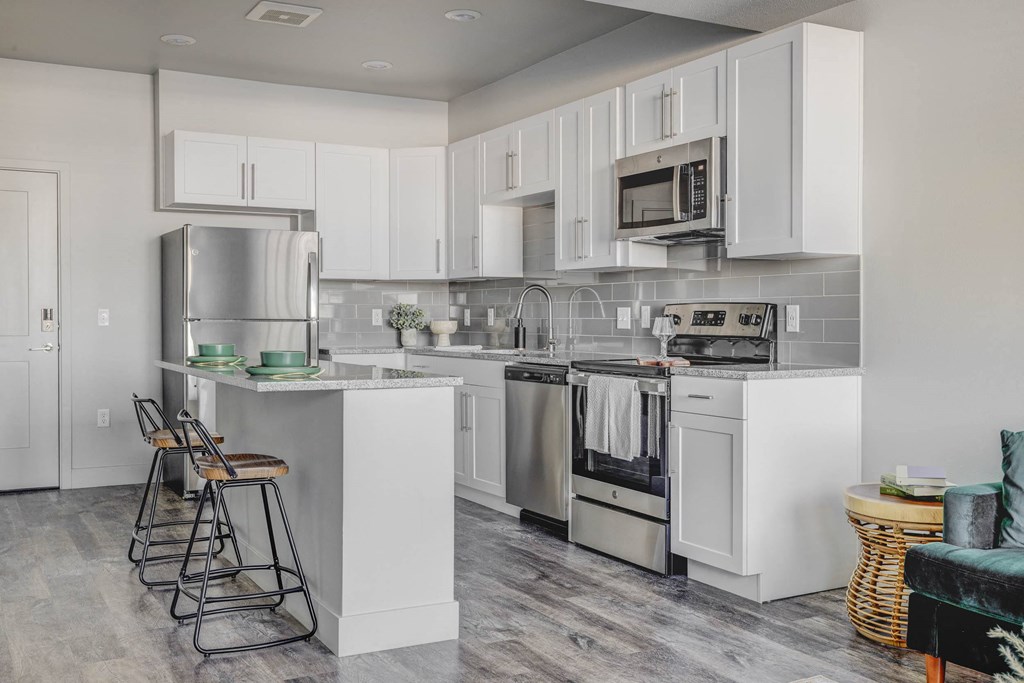 a kitchen with white cabinets and stainless steel appliances
