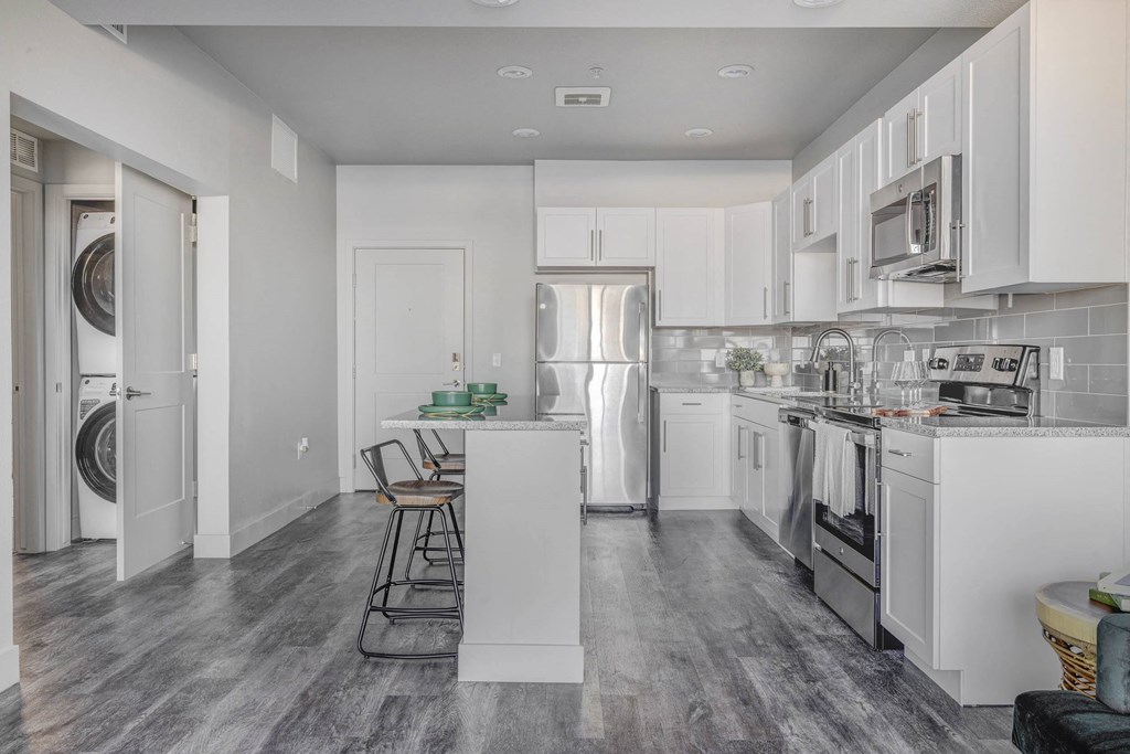 a renovated kitchen with white cabinets and stainless steel appliances