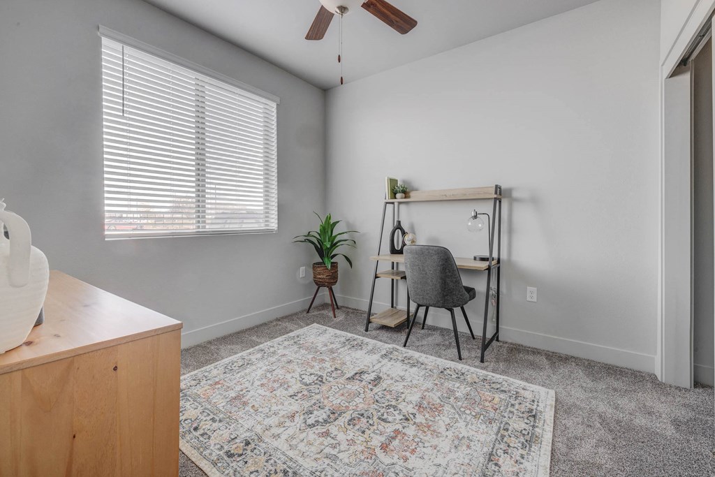 an office space with a desk and a chair and a window