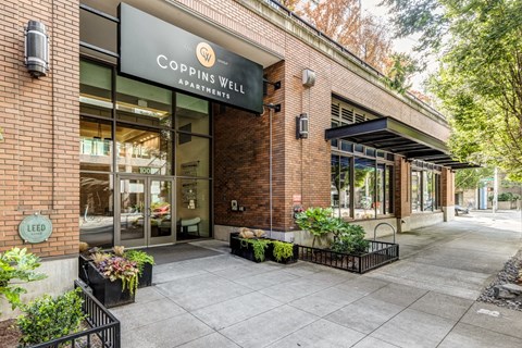 the facade of a building with a sign that reads Coppins Well Apartments
