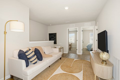 A living room with a white couch and a gold floor lamp.