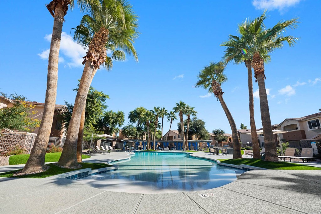 a large swimming pool with palm trees around it