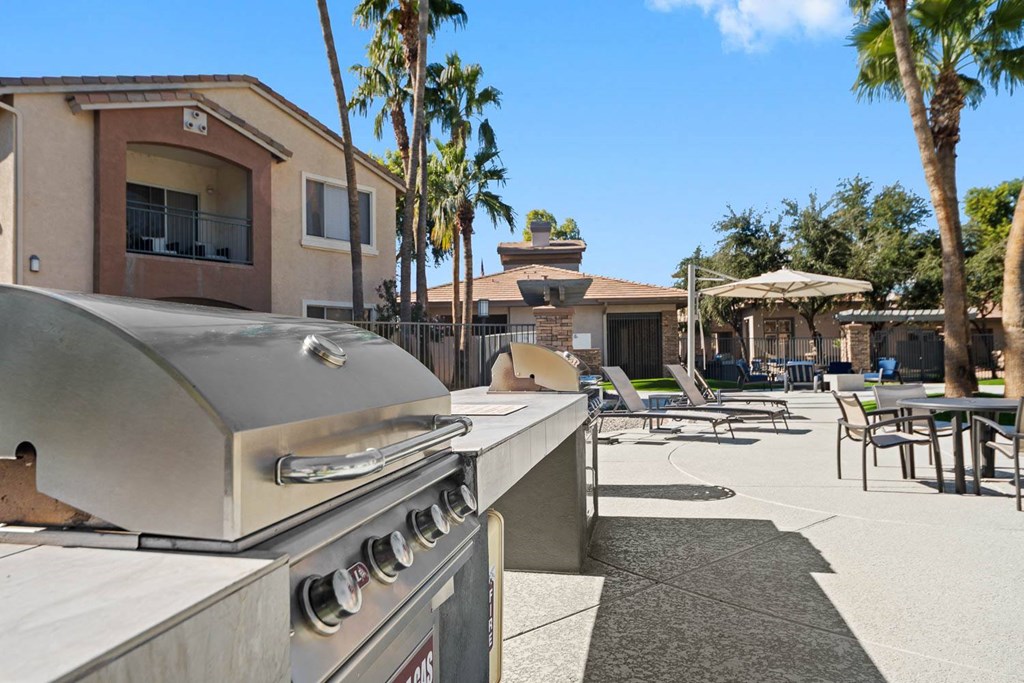 a barbecue grill in a patio with tables and chairs