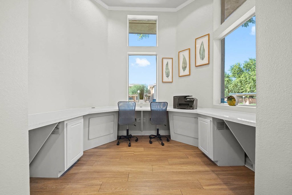 a home office with two desks and a window
