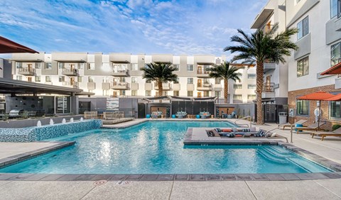 A large swimming pool in front of apartment buildings.