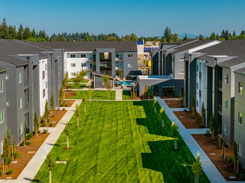 A row of modern houses with green lawns in front.