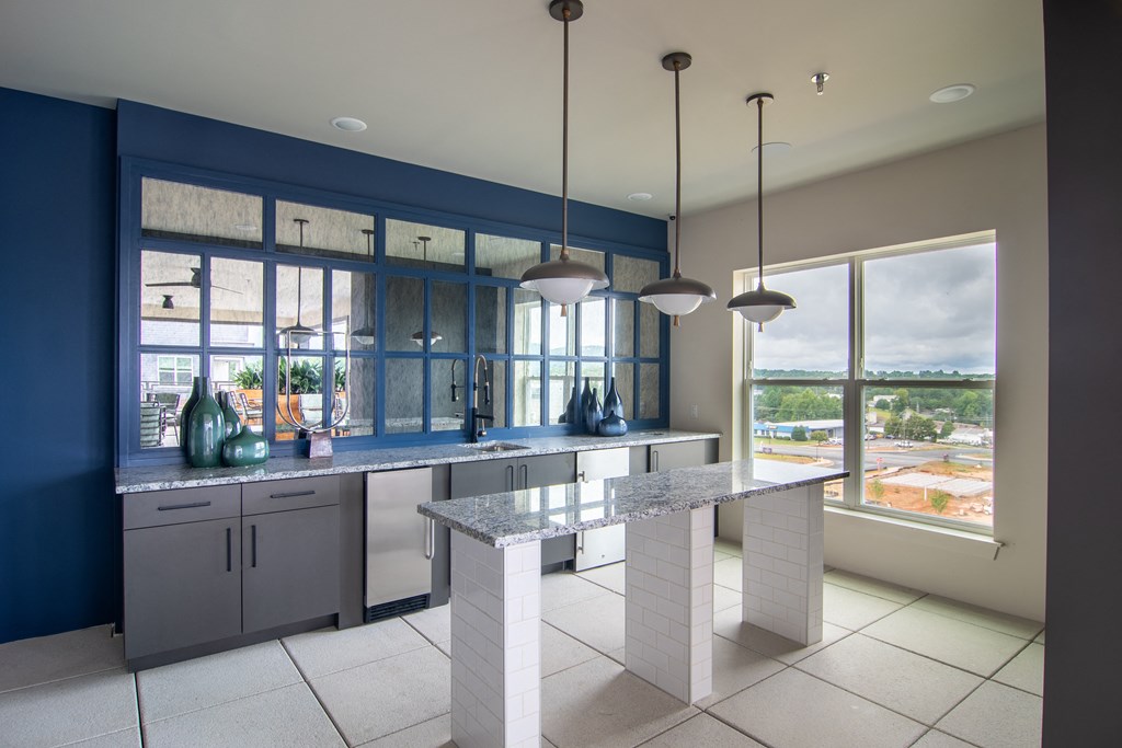 a kitchen with blue and white cabinets and a white island with a marble countertop