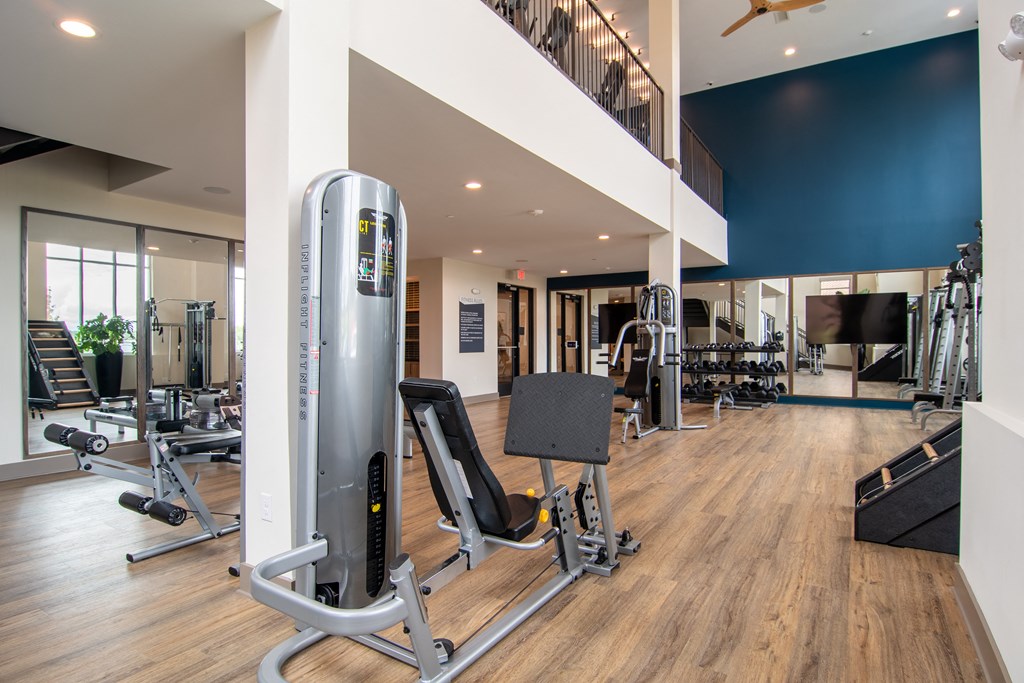 a spacious fitness center with cardio machines and weights